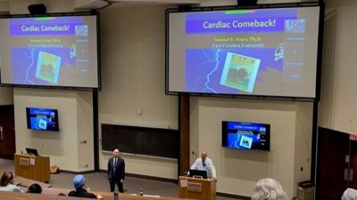 Sam Sears, Ph.D., is introduced to live and virtual audiences by Paul Mounsey, M.D., director of the Division of Cardiovascular Medicine.