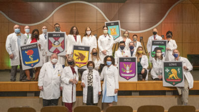 Faculty advisers from the seven academic houses in the College of Medicine stand behind, from left, James Graham, M.D., executive associate dean for student affairs; Susan Smyth, M.D., Ph. D., dean of the College of Medicine; Sara Tariq, M.D., associate dean of student affairs; and Romona Davis, M.D.