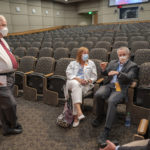 Before the town hall, Robert Hopkins Jr., second from right, talks with James Graham (standing), Michelle Krause and Steppe Mette, right. All four physicians made up a panel of experts who answered questions at the meeting.