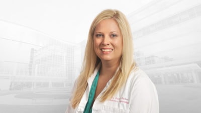photo portrait of Mary Luann Racher, M.D., in white coat.