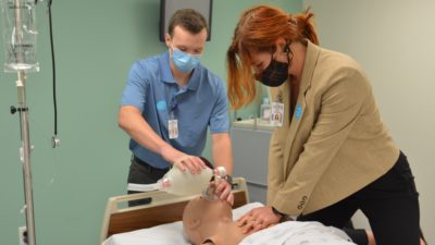 Spencer Parnell and Caroline Geels, first-year students in the College of Medicine's new 3-year M.D. program, practice CPR on a training manikin at the UAMS Northwest Regional Campus in Fayetteville.