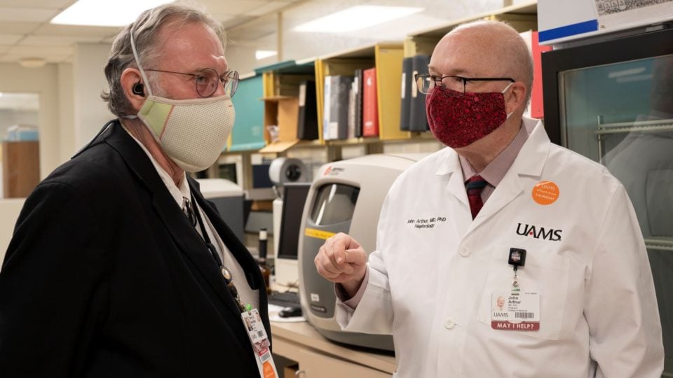 Terry Harville, M.D., Ph.D., consults with John Arthur, M.D., Ph.D., in the UAMS Pathology Lab.