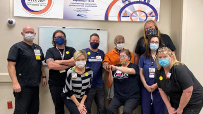 From left to right, (back row), Travis Hill, Jerry Halpain, Dewayne Allen, Andrew Warr, and (front row) Sherry Johnson, Margaret Glasgow, Karen Dickinson and Patti Griffey surround Hal the mannekin (in orange), representing the woman's partner, as he anxiously checks his watch.