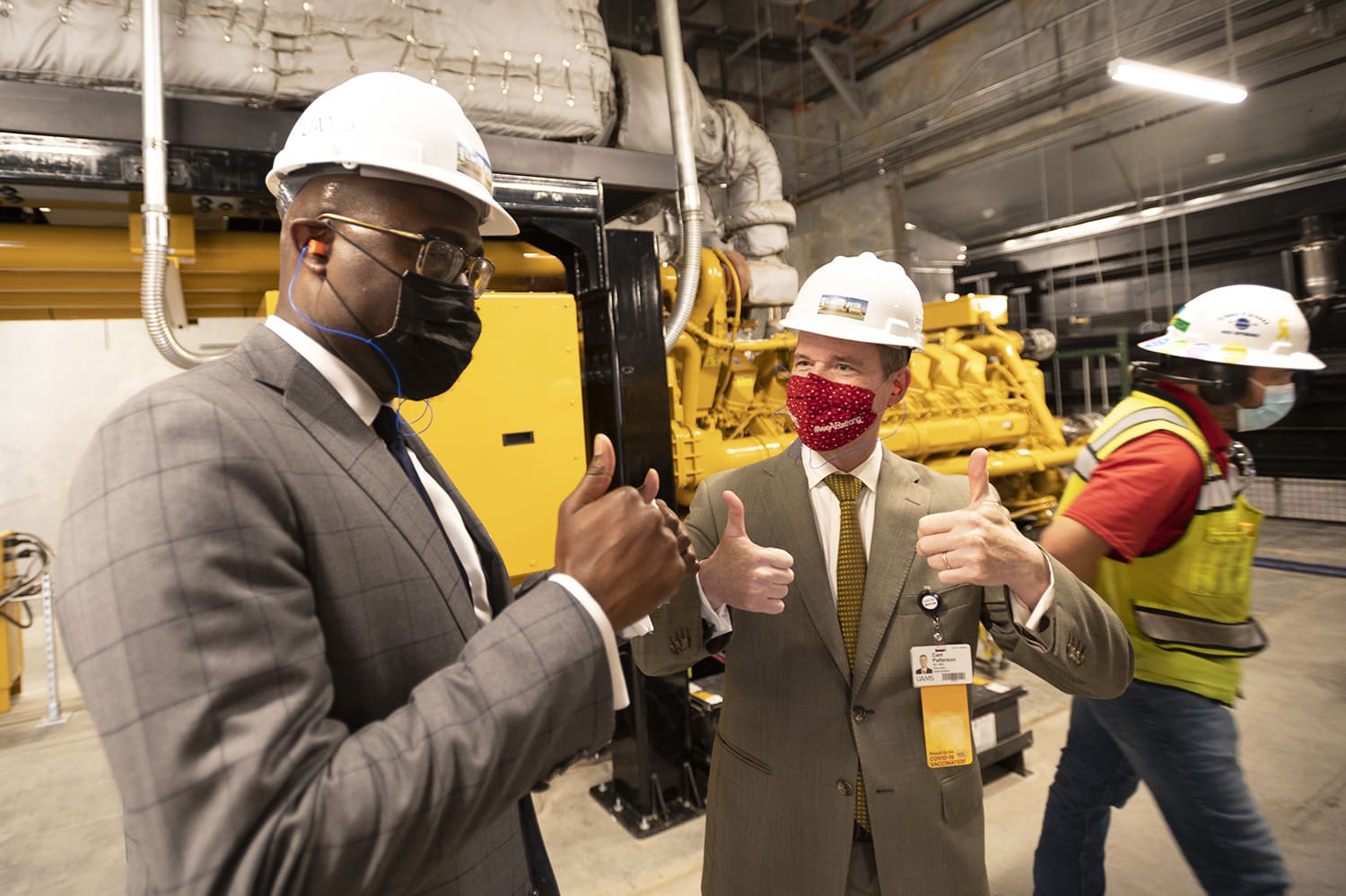 Chancellor Cam Patterson, right, shares a thumbs up with Little Rock Mayor Frank Scott Jr. after the mayor turned on one of the generators at the new power plant at the end of the facility's official opening.