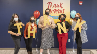 Institutional Advancement team members in front of Thank UAMS Day sign