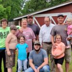Mike Booker (white shirt) was diagnosed with frontotemporal dementia in 2010. He is shown with his daughter, son-in-law, son and grandchildren.