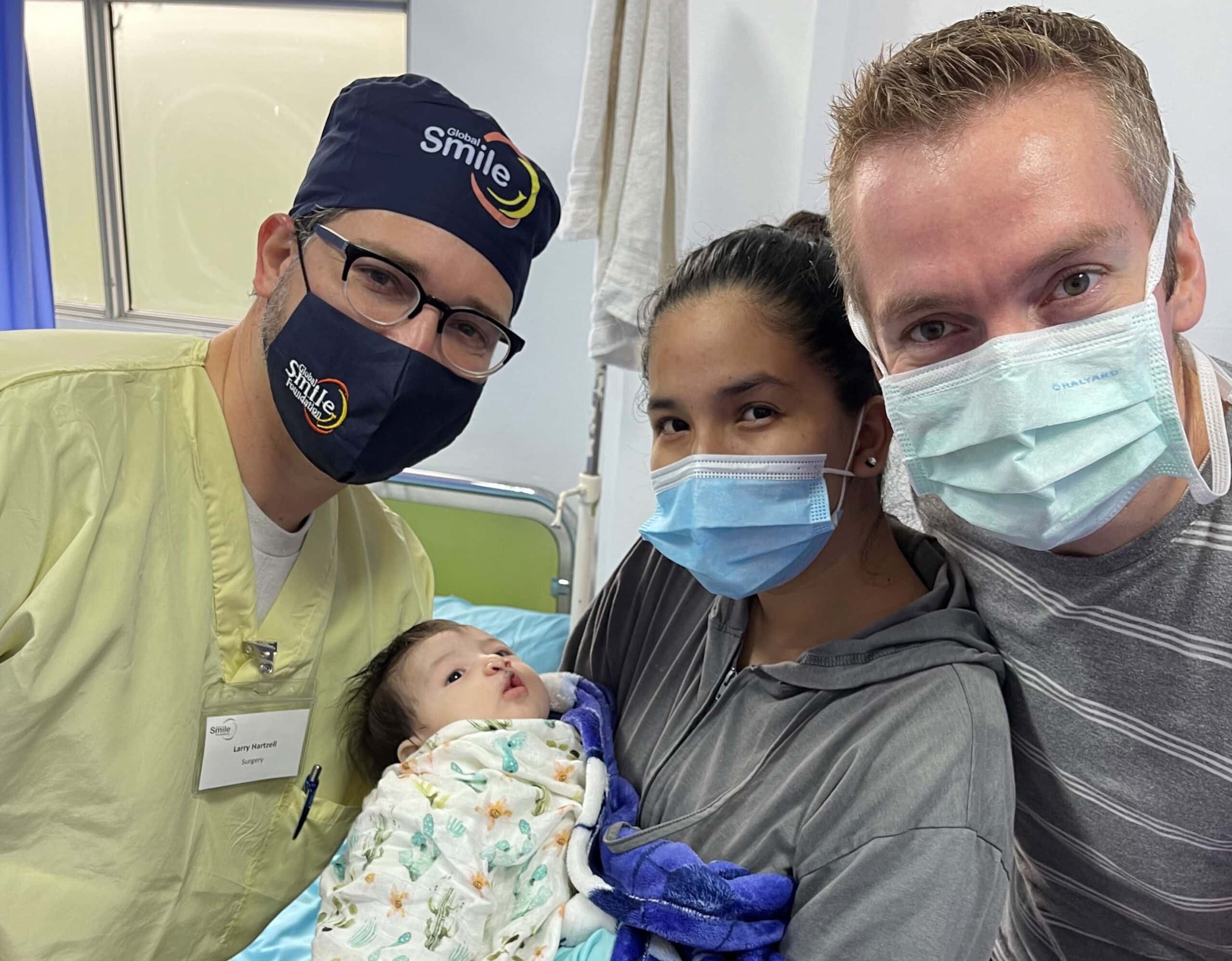 Larry Hartzell, M.D., and Jeff Dorrity, M.D., with one of their tiny cleft patients and her mother in Ecuador
