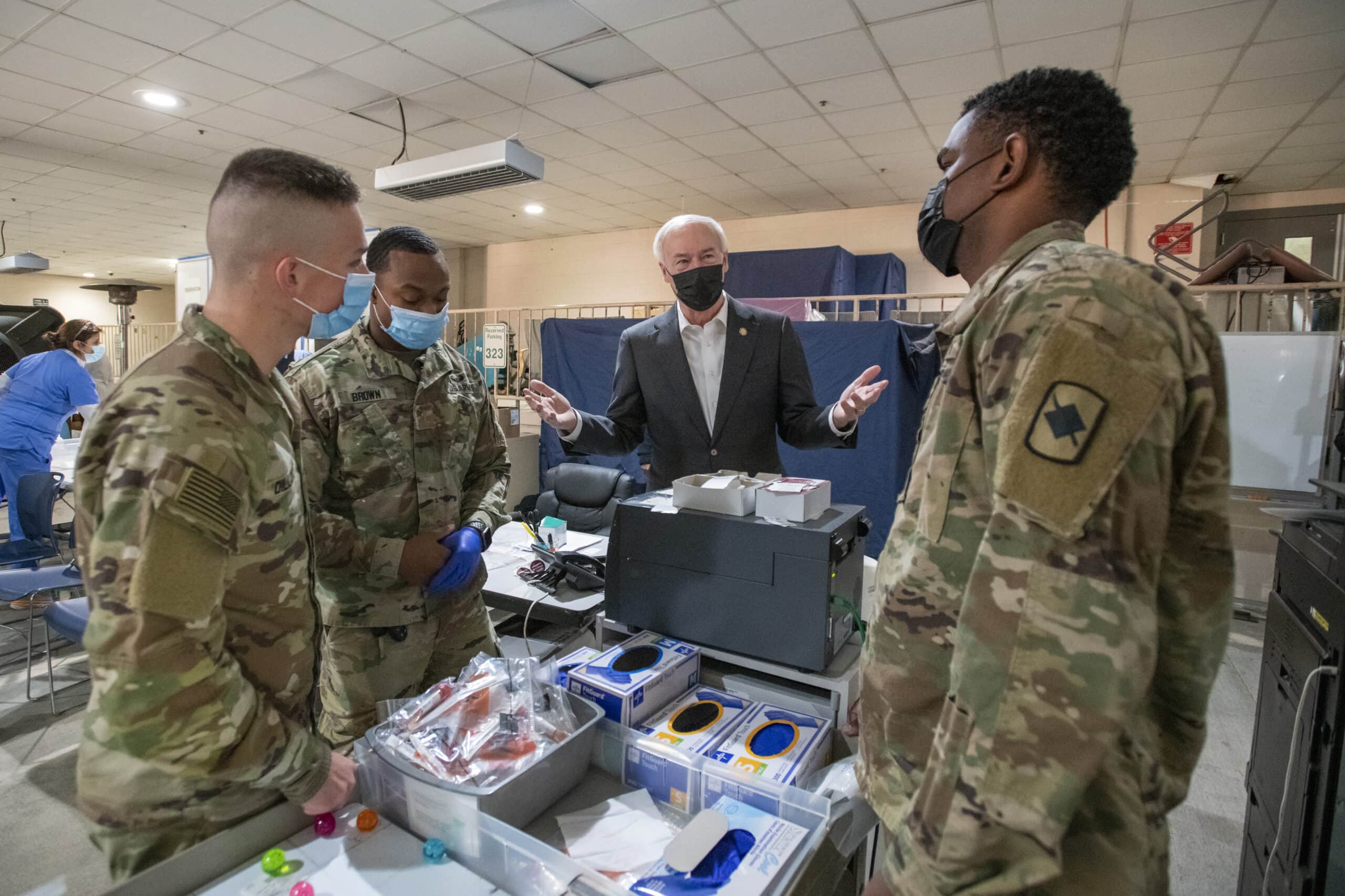 Gov. Asa Hutchinson talks with National Guard soldiers who have been deployed to UAMS to help with COVID-19 testing.