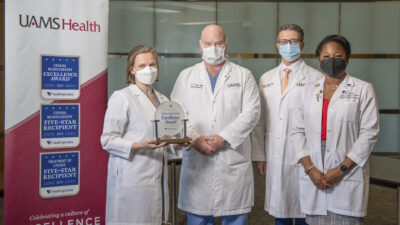 Pictured with the award, left to right: Erika Petersen, M.D., neurosurgeon; John Day, M.D., chair of the Department of Neurosurgery; Viktoras Palys, M.D., neurosurgeon; and Ebonye Green, APRN, Department of Neurosurgery. Not pictured: Analiz Rodriguez, M.D., neurosurgeon.