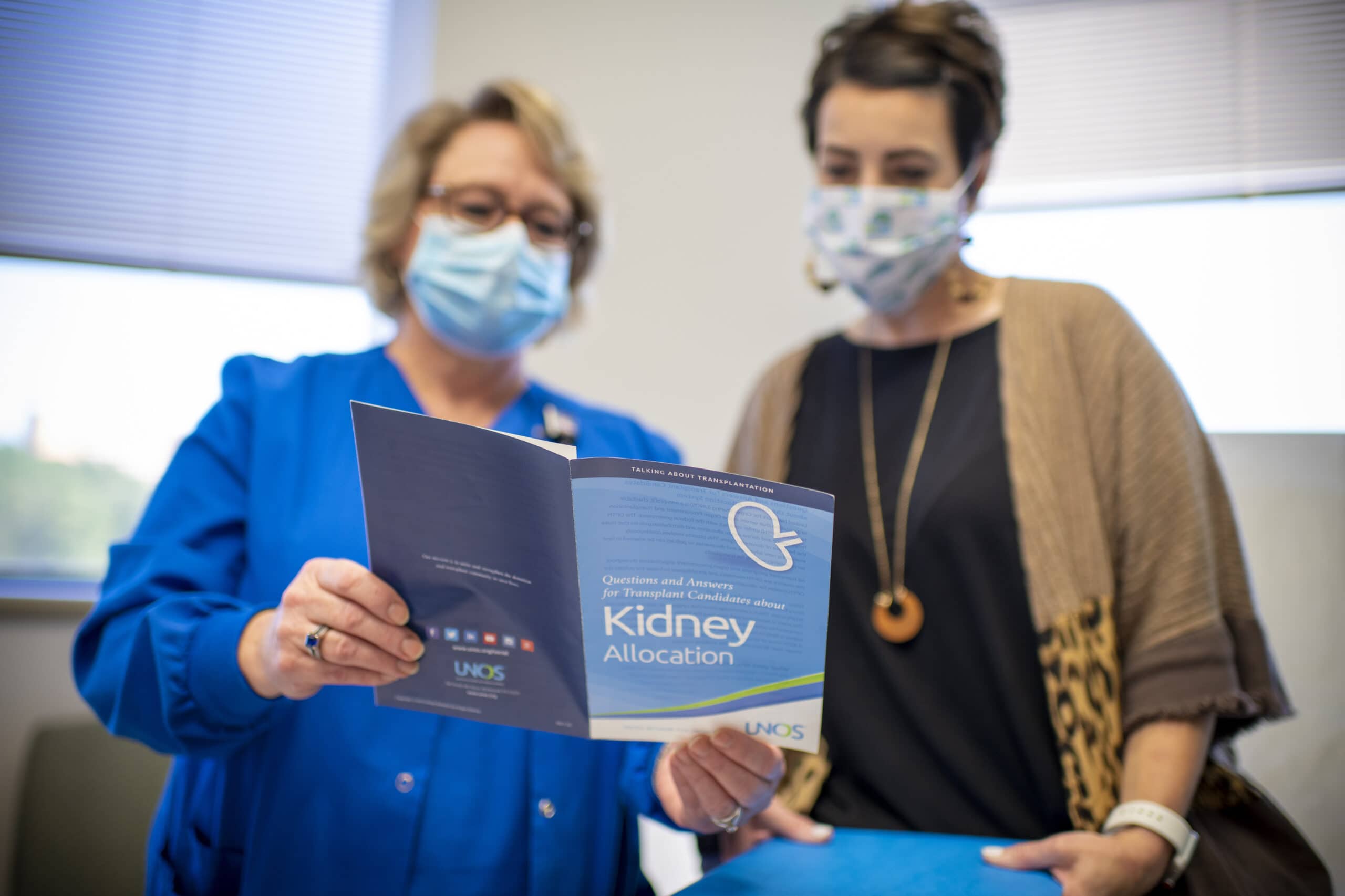 File photo; UAMS employees look through a report on the kidney transplant program.