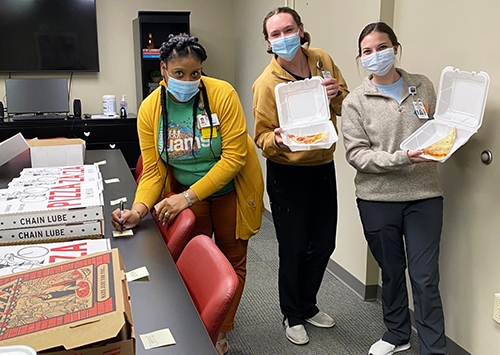 Three of the College's students enjoy some free slices of 'radical pizza.'