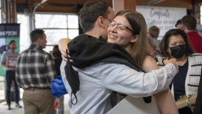 Heather Morgan, who matched to a family medicine residency at Harrison Medical Center in Bremerton, Washington, and also won a jar of cash by being the last senior called to the stage, collect hugs after the ceremony. All the seniors contributed a dollar to the jar as they walked across the stage.
