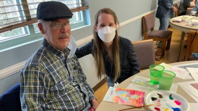 John Helmcamp, left, shows his artwork to Suzanne Dhall.