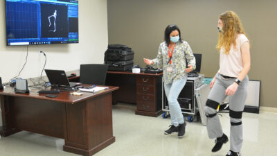Nadia Marconi, left, demonstrates a motor task to a student volunteer while using the new motion-capture system.