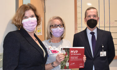 Tracey Carey, center, minutes after Chancellor Cam Patterson, right, presented her with the April 2022 MVP award. Laura Dunn, M.D, director of the UAMS Psychiatric Research Institute, left, congratulates her.