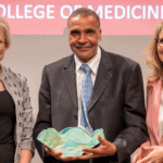 Billy Thomas, M.D., MPH, a professor of pediatrics, (center) is the UAMS College of Medicine’s 2022 Distinguished Faculty Service Award recipient. He is joined on stage by his nominator, Renee Bornemeier, M.D., (left) and Susan Smyth, M.D., Ph.D., executive vice chancellor and dean.