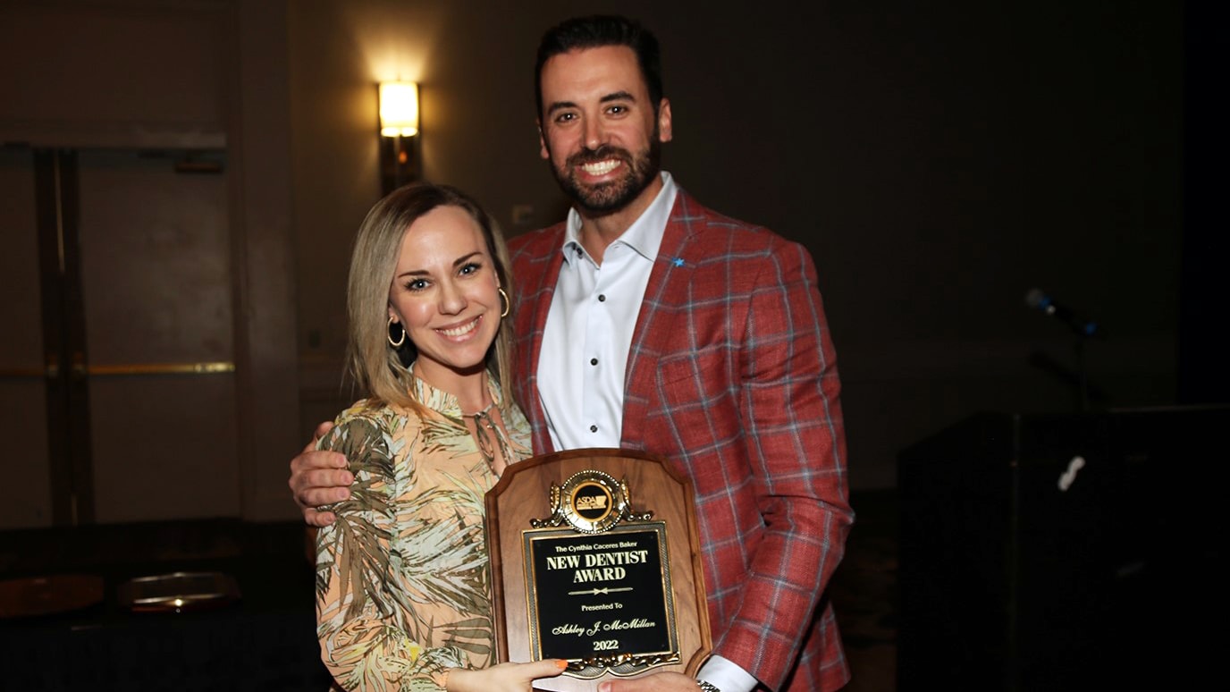 Ashley McMillan, left, receives the 2022 Cynthia Caceras Baker New Dentist Award from Keith Jones, the 2021 recipient. The award is named in honor and memory of Cynthia Caceras Baker, who passed away unexpectedly while serving on the ASDA New Dentist Committee.