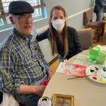 John Helmcamp shows his artwork to Suzanne Dhall at the first workshop on March 29.