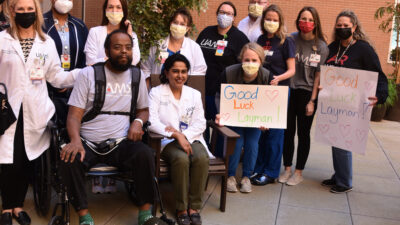 Layman Roseby sits next to Kalaivani Sivakumar, M.D., surrounded by his UAMS and care team, upon being discharged.