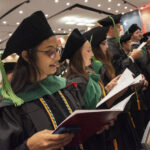 Newly robed graduates recite the Hippocratic Oath in unison.