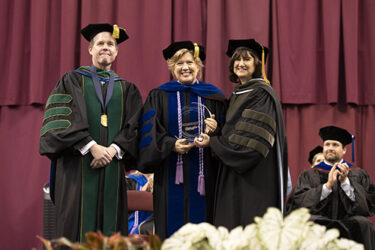 Pam De Gravelles, centro, recibe el Premio del Canciller a la Excelencia en Educación para la Sociedad y la Salud.