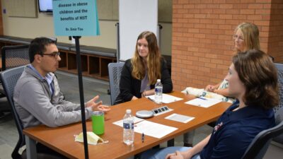 UAMS’ Emir Tas, M.D., (left) leads a table discussion about fatty liver disease and the benefits of high-intensity interval training.