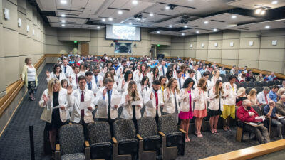 The Physician Assistants Class of 2024 stands to recite and take the Professional Oath on May 27 in the Smith Auditorium.