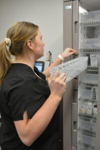 A UAMS nursing student retrieves "medication" in the medication preparation room through a fingerprint-activated Pyxis medication access system.