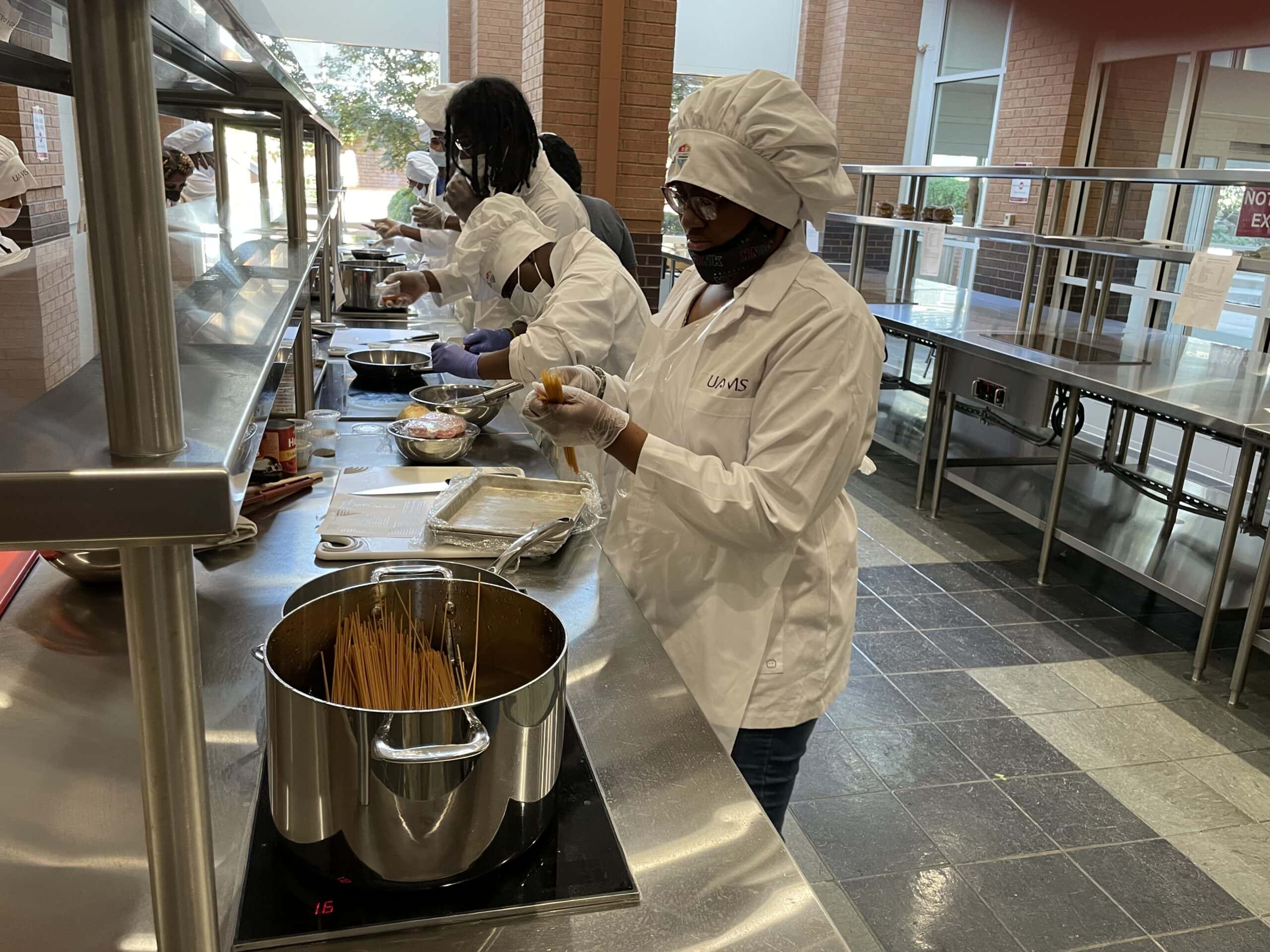 Students from Pathways Academy's Pine Bluff RAMP-UP program prepare spaghetti and meat sauce during a trip to UAMS' Culinary Medicine Kitchen.
