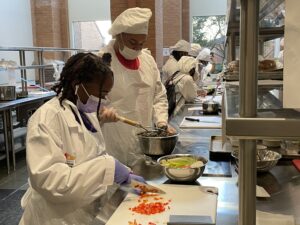 Makya Terry (left) chops vegetables as JaVoni Jackson mashes black beans to form a burger mixture June 20 during the Pathways Academy scholars’ visit to the Culinary Medicine Kitchen at UAMS’ Donald W. Reynolds Institute on Aging. 