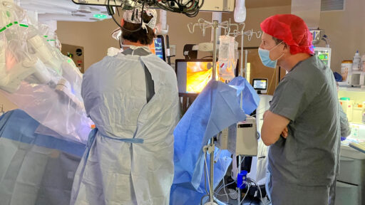 Keith Goldberg, M.D., right, watches closely as Conan Mustain, M.D., operates the daVinci robot during a colectomy.