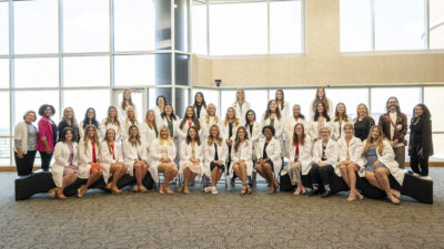Students in the audiology Class of 2026 and the speech-language pathology Class of 2024 and faculty from the Department of Audiology and Speech Pathology gather for a group photo after the White Coat Ceremony on Aug. 19