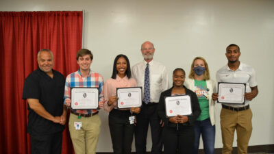 The 2022 Stead Scholars show their certificates of completion. From left to right, the scholars are: Benjamin Trussell, Alexandria Cade, Khariana Hobbs, and JaKory Thomas. Not in the photo is Raven Beck.