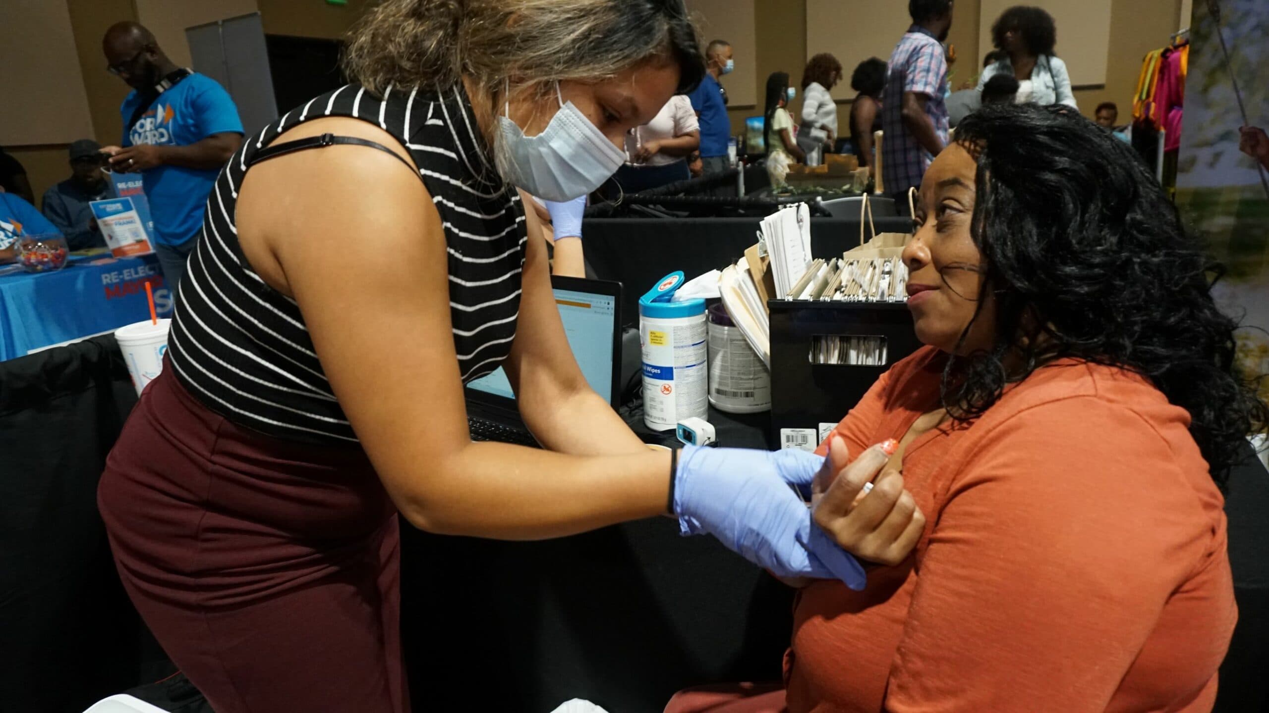 Beatriz Mondragon with the Arkansas Minority Health Commission provides a health screening for Marcovous Williams during the UAMS Midsouth Black Expo.