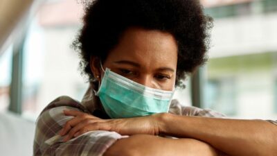 woman wearing surgical mask with arms crossed