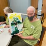 Preston Hurlburt shows off his painting during an Art for Parkinson's class in the spring.