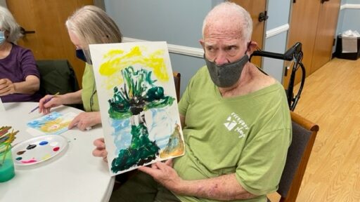 Preston Hurlburt shows off his painting during an Art for Parkinson's class in the spring.