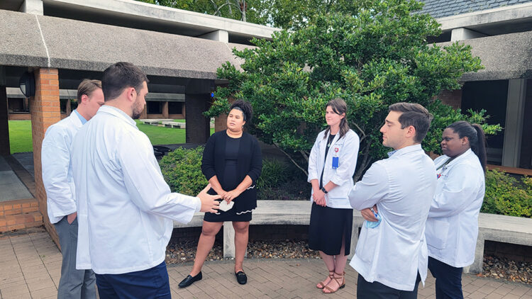 Allert, third from left, listens to the students as they discuss the Physician Assistant program and stand outside the department's offices.
