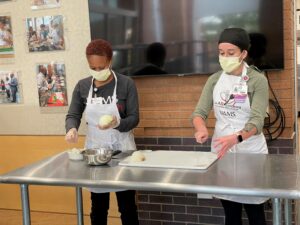 Jasmine Washington, left, and Alyssa Frisby demonstrate how to safely dice an onion.