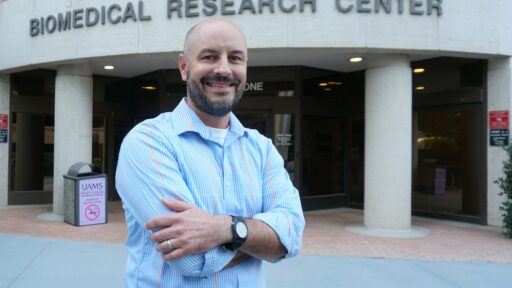 UAMS’ Daniel Voth, Ph.D., is leading the NIH grant supporting renovations to increase infectious disease research space in the building behind him.