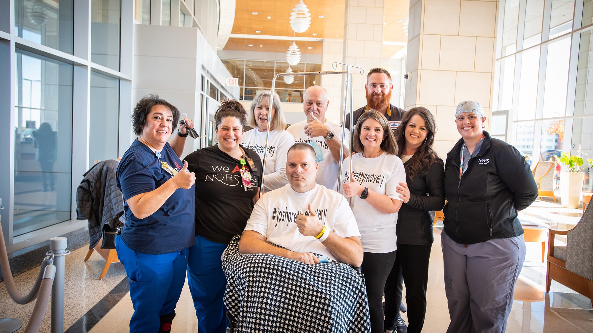 Josh Pretty, seated, gives a thumbs up just before he leaves UAMS Medical Center for what would turn out to be a shorter-than-expected stay in a local rehabilitation hospital. His wife, Alissa Pretty, third from the right, also does the same.