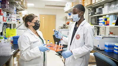A Health Career University student works with an instructor in a lab at the University of Arkansas for Medical Sciences.