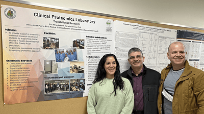 Proteomics staff from Puerto Rico pose in front of their poster presentation at the UAMS Winthrop P. Rockefeller Cancer Institute.