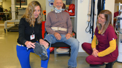 Jennifer Vincenzo, left, and Heather Vaughn, a UAMS physical therapist, work with a patient.