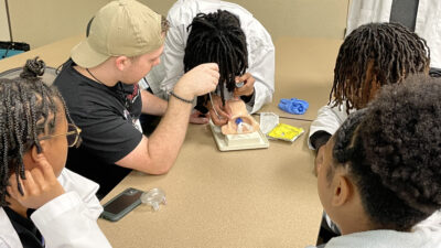 A student practices intubation on a manikin during the UAMS Pathways Academy College of Health Professions Day.