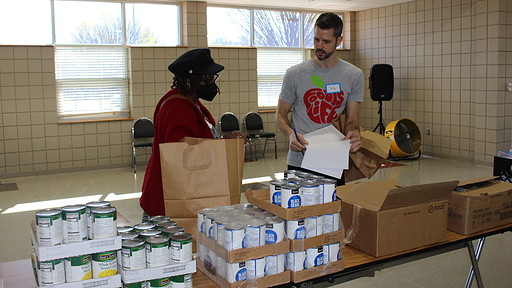Josh Harris, executive director of Well Fed, helps a patient on the first food delivery day for Good Food Rx.