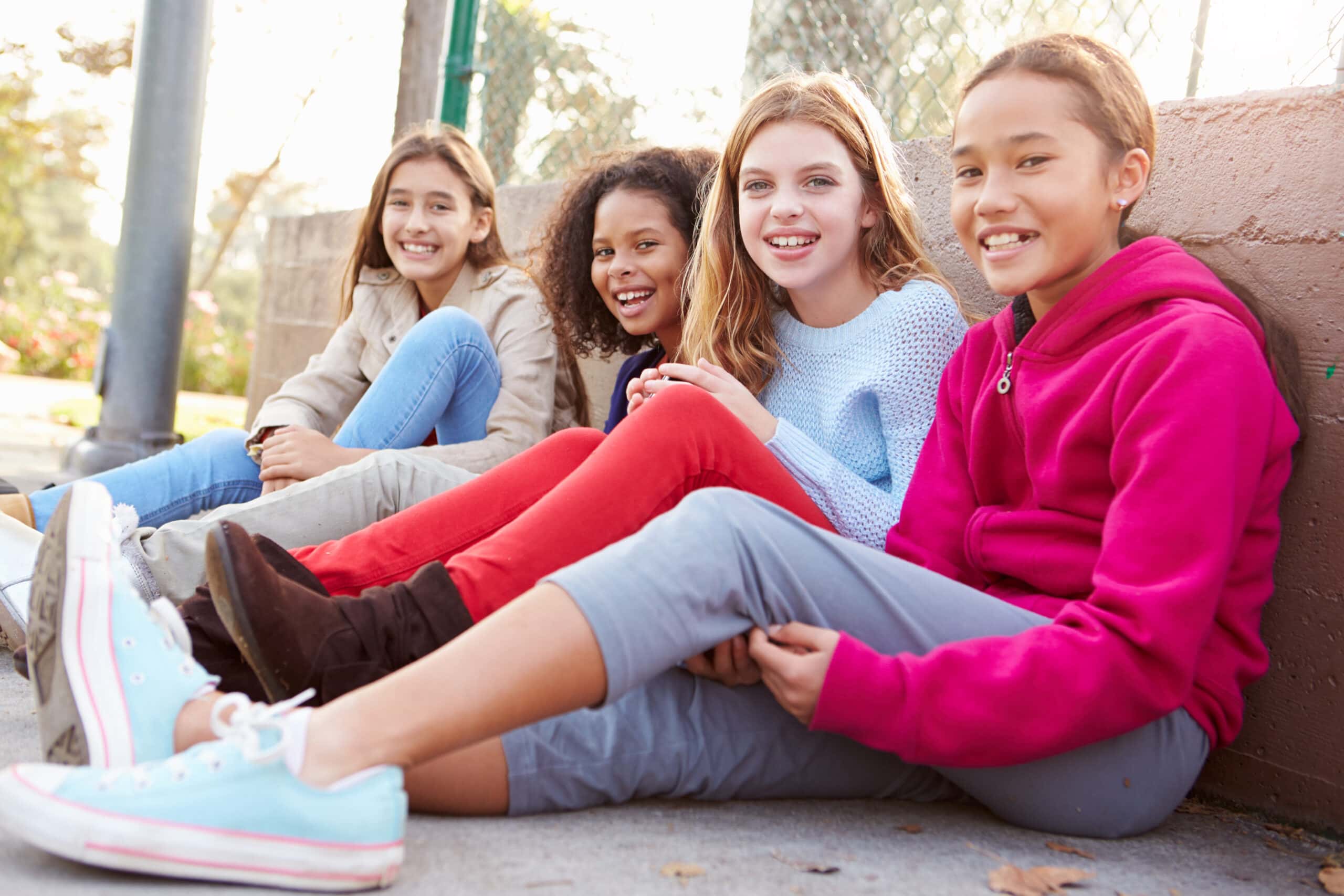 Four Young Girls Hanging Out Together In Park