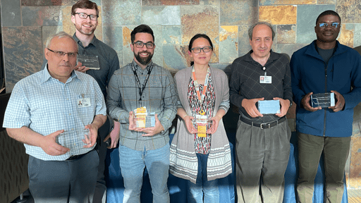 A group of scientists holding award plaques