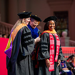 A hood is placed on a graduate's shoulders during the College of Nursing ceremony.