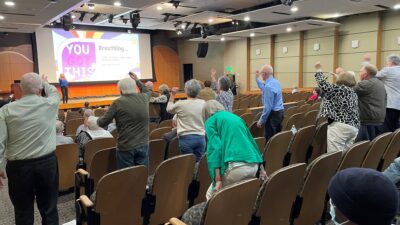 From the stage, Patty Oeste leads the audience in exercises to benefit Parkinson's patients.